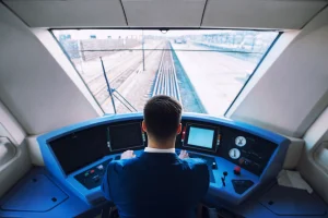 Maquinista en la cabina de un tren en marcha, representando el riesgo de fatiga operativa y absentismo laboral en el sector ferroviario