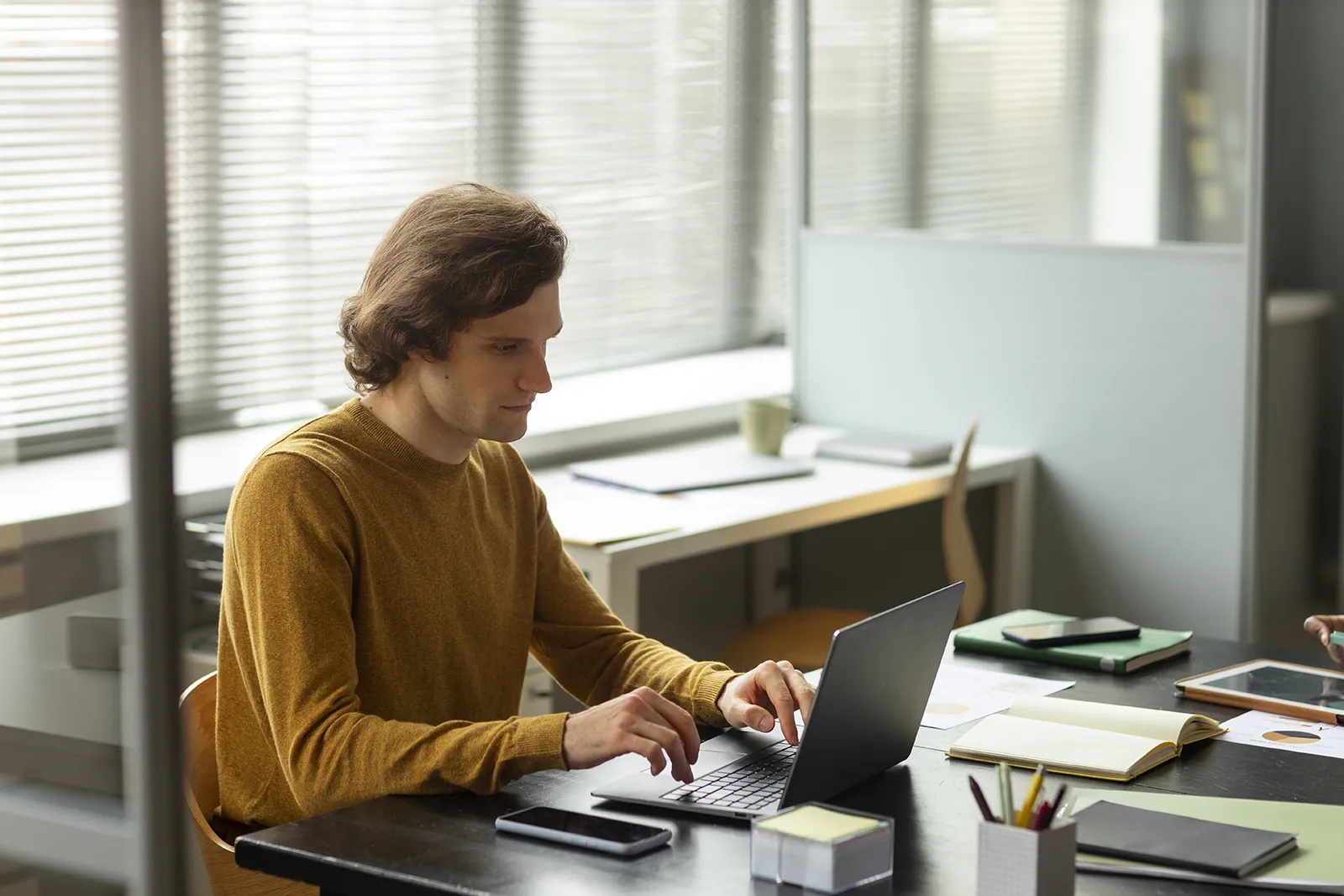 Profesional de RRHH trabajando en un portátil calculando el índice de absentismo laboral y los costes ocultos de las bajas en una empresa de transporte